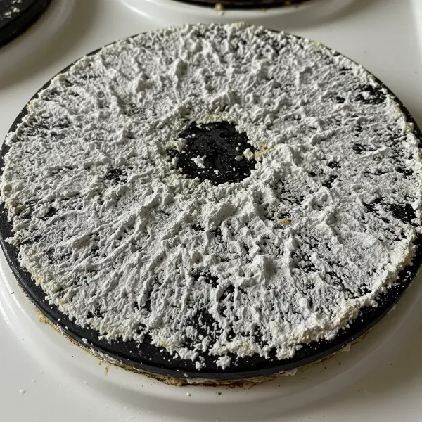 Close-up of limescale buildup on an electric cooker heating plate, showing white chalky deposits